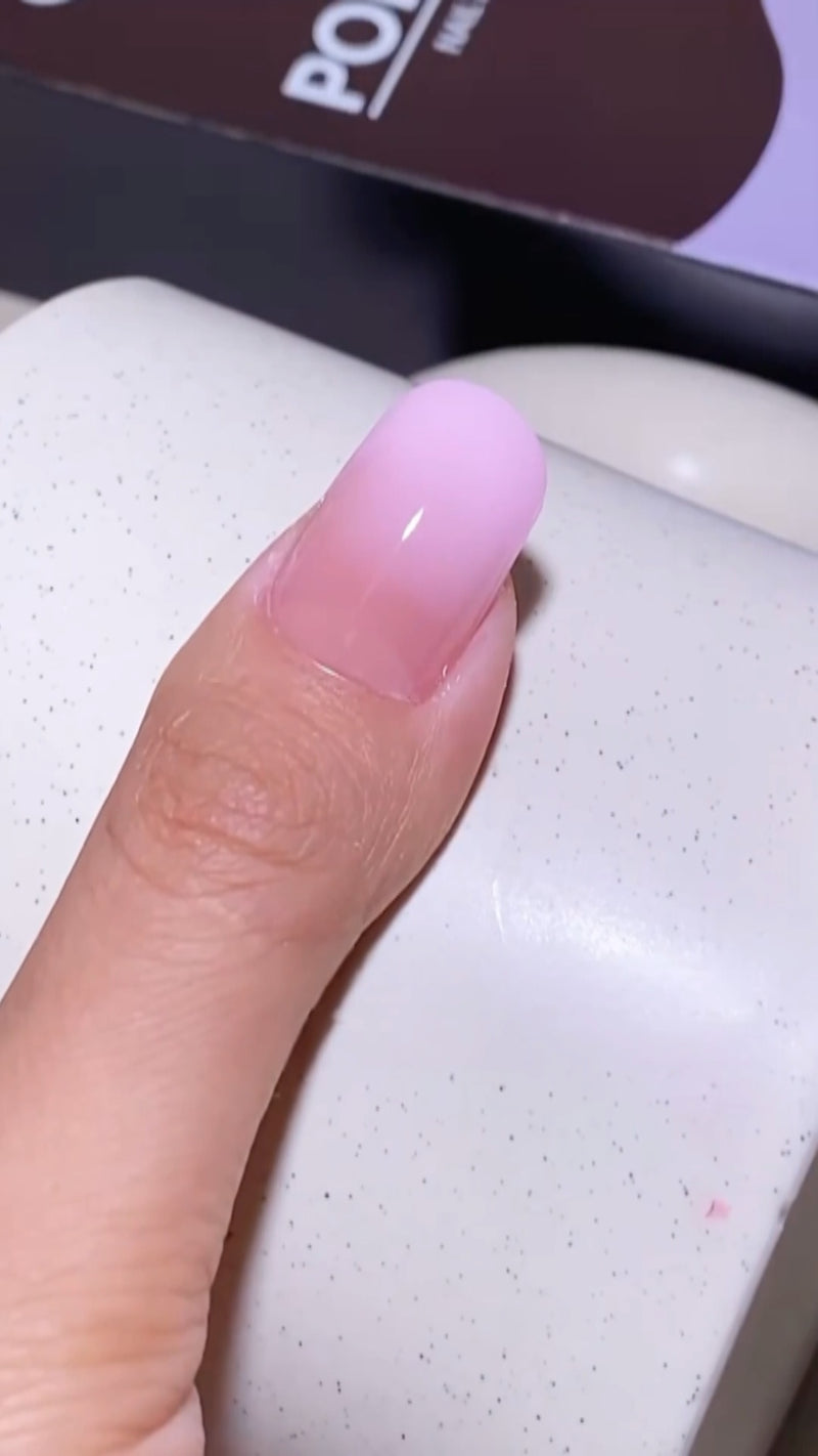 A beautiful aesthetic transition shot showing short natural nails on one hand next to long, flawless clear gel extensions on the other.