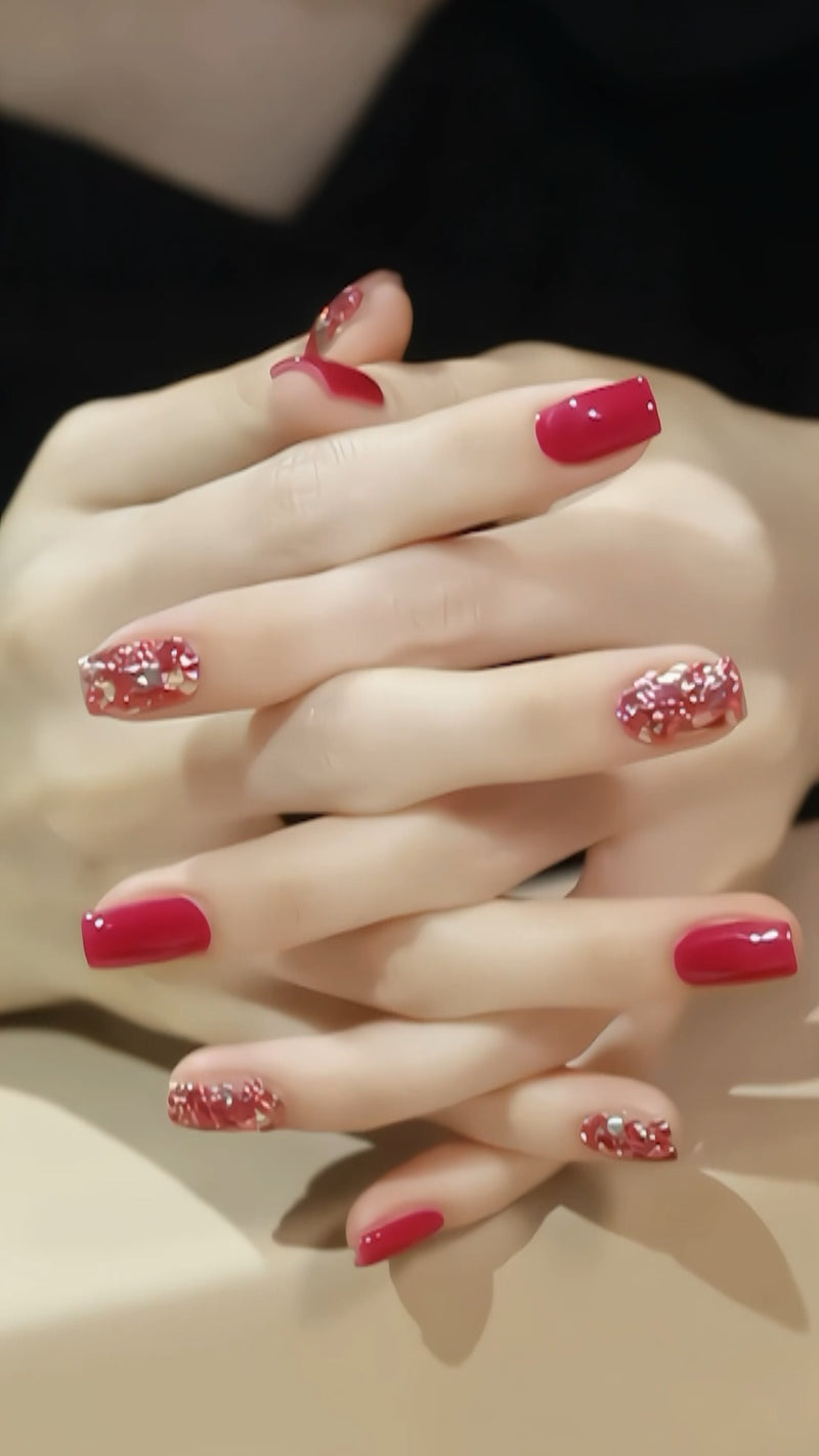 A manicured hand showing a contrast between opaque solid pink gel nails and a brilliant silver glitter accent nail.