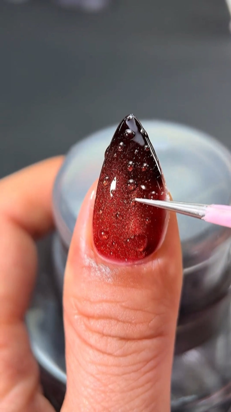A satisfying close-up view of an old layer of nail polish popping off cleanly in one solid piece, revealing a shiny, unmarred natural nail plate.
