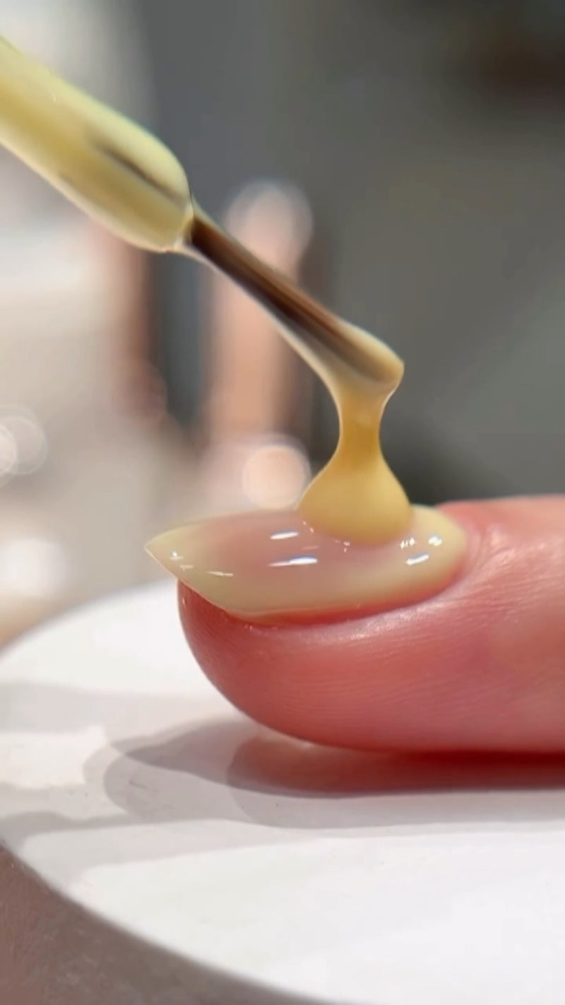 A close-up side profile view showing a clear soft builder gel self-leveling into a perfect smooth dome shape on a natural nail.