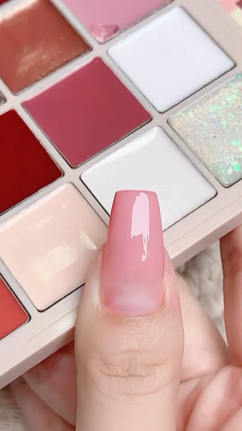 A close-up view of a brush smoothly wiping a rich terracotta pink solid cream gel polish onto a nail wit
